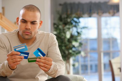 Man-sitting-holding-credit-cards-.jpg