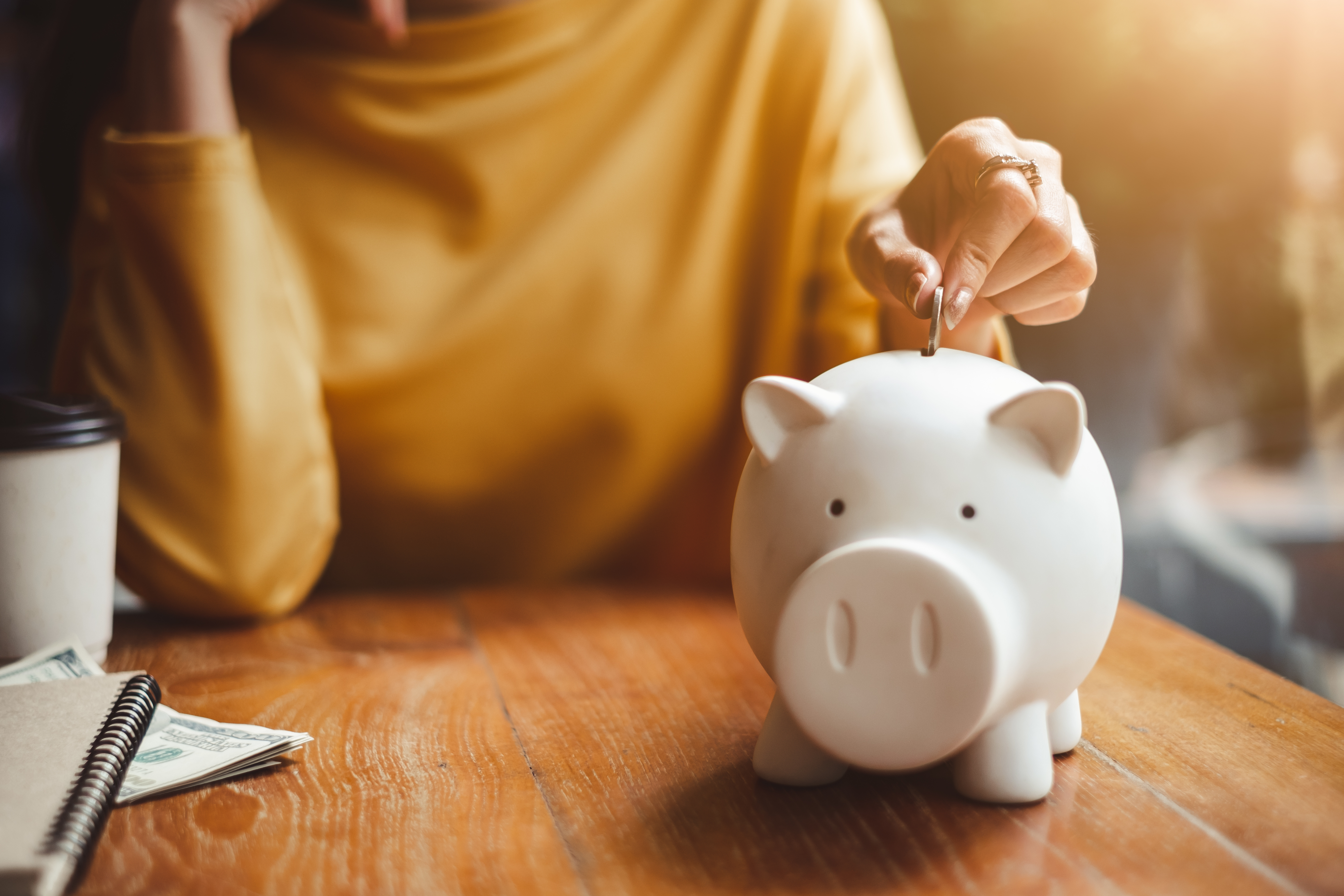 Woman-Putting-change-in-piggy-bank.-jpeg