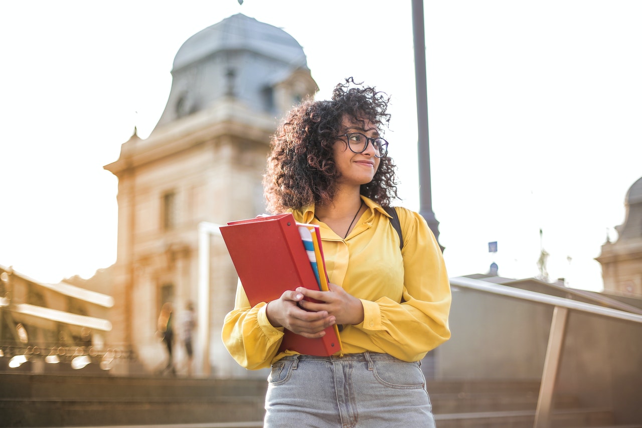 woman-in-yellow-jacket-holding-red-book.jpg