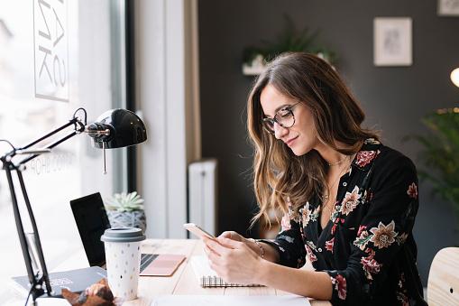 woman-sitting-at-desk-on-phone-.jpg